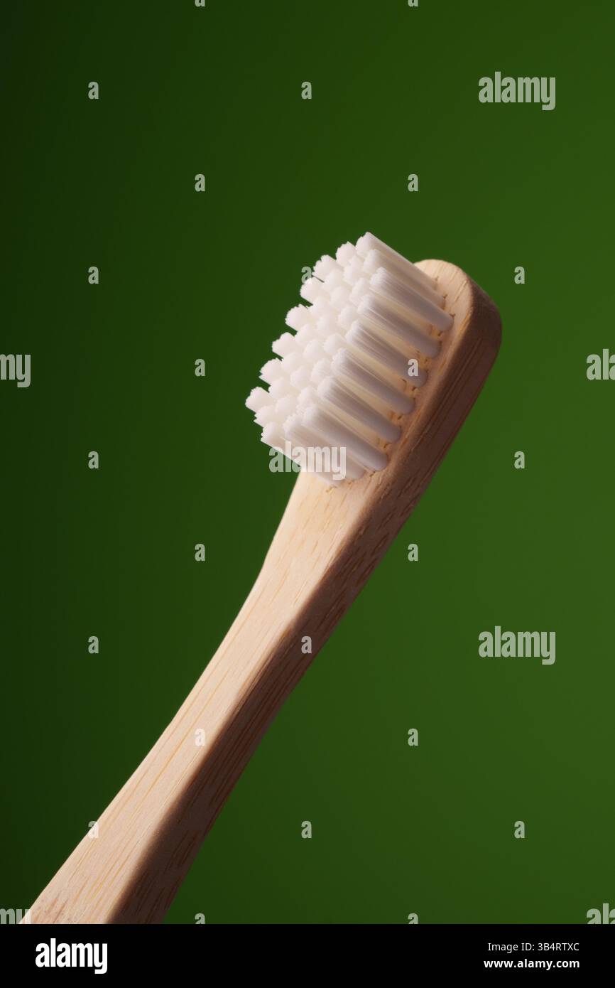 Eine hölzerne Zahnbürste auf grünem Hintergrund. Mundgesundheit. ECO-Zahnbürste. Stockfoto