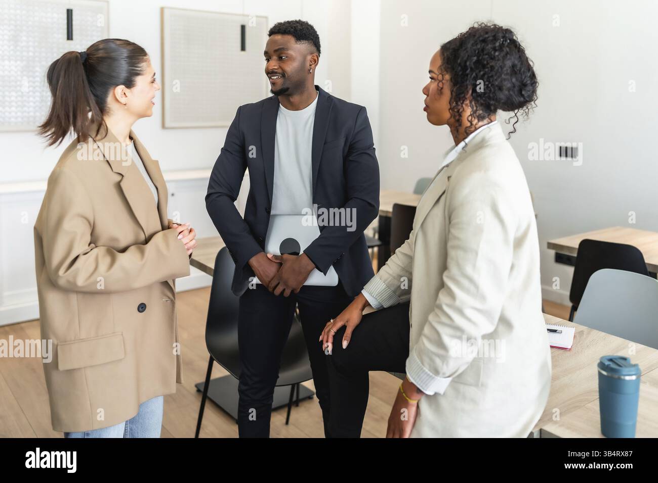 Geschäftskollegen diskutieren ein Projekt, tauschen Ideen aus und arbeiten bei einem informellen Meeting in einem modernen Büro zusammen Stockfoto