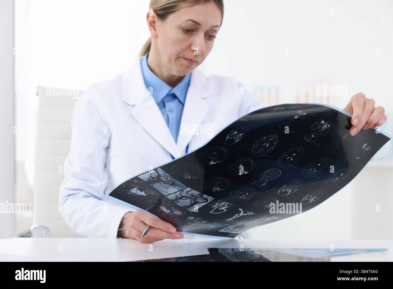 Arzt untersucht MRT-Scan am Schreibtisch im Krankenhaus, Nahaufnahme Stockfoto