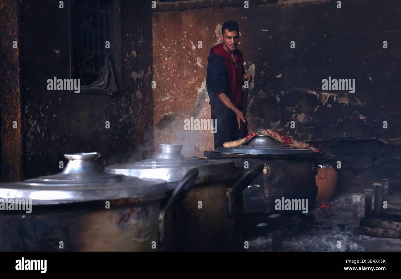 23. April 2022, Rafah, Gazastreifen, Palästina: Palästinenser kochen über Feuer. Suleiman Al-Aloul Madi verwendet seit 50 Jahren Feuer, um Speisen zu kochen, während er Mahlzeiten nach den Wünschen des Kunden zubereitet. Dies hilft ihm auch, die schwierigen Bedingungen im Gazastreifen zu überwinden. (Bild: © Samar Abu Elouf/ZUMA Press Wire Service) Stockfoto