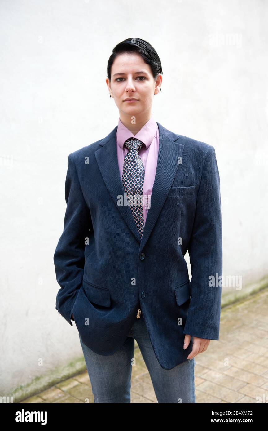 Eine junge Erwachsene, kaukasische Frau, gekleidet als modischer Mann, spaziert durch die Straßen der Stadt Tilburg, Niederlande. MR=JA Stockfoto