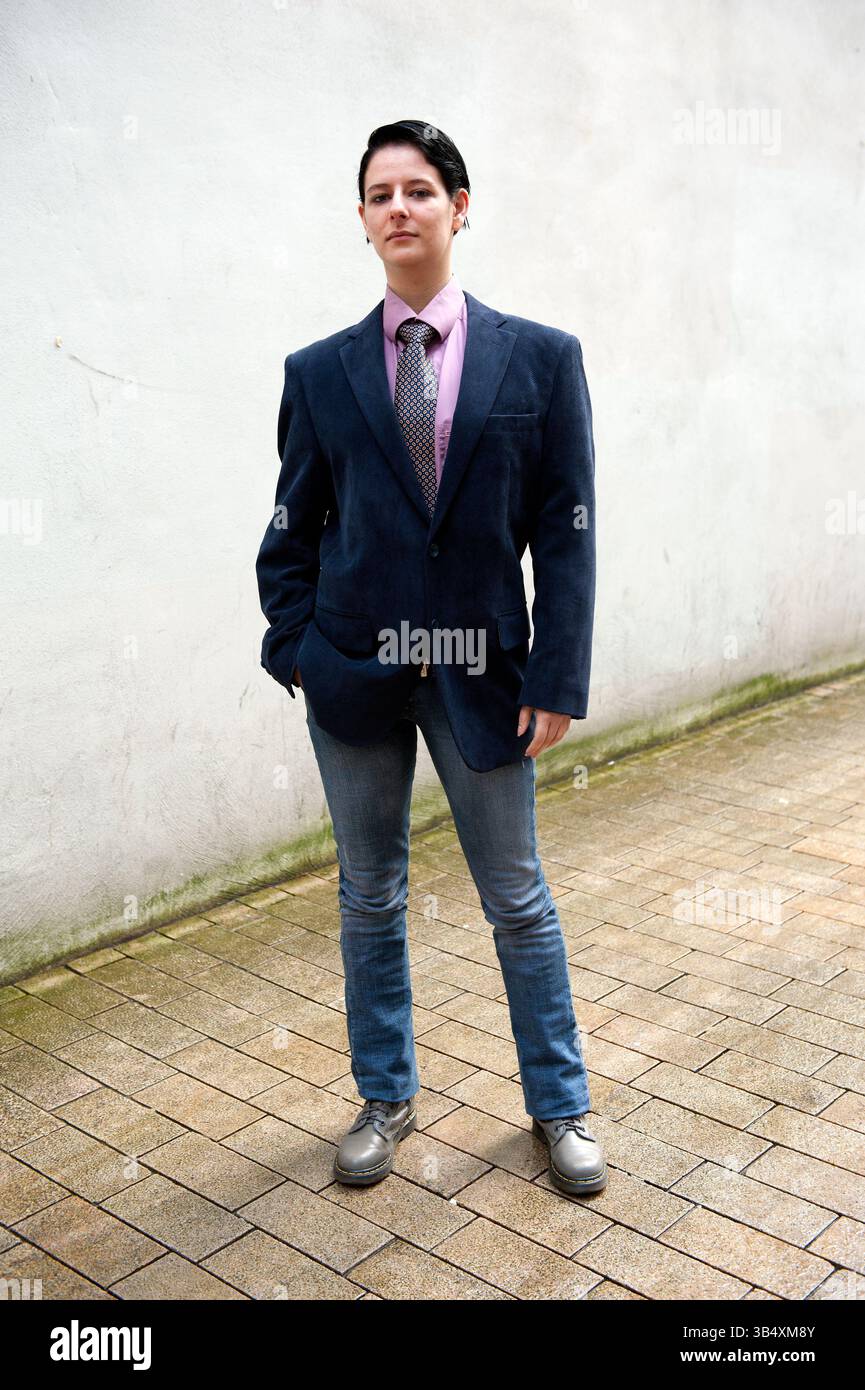 Eine junge Erwachsene, kaukasische Frau, gekleidet als modischer Mann, spaziert durch die Straßen der Stadt Tilburg, Niederlande. MR=JA Stockfoto