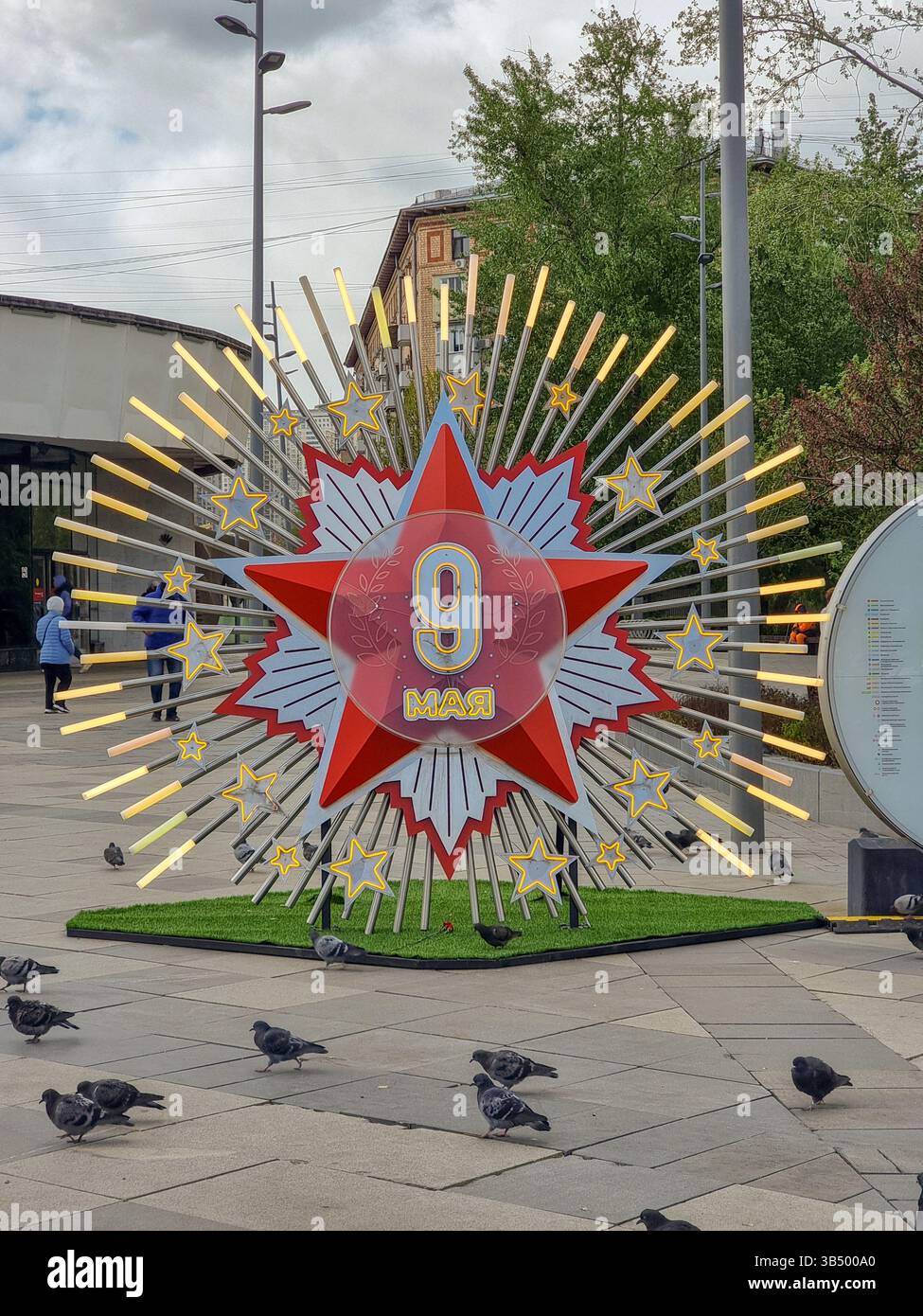 Schild für die Feier des 9. Mai 2025, 80 Jahre nach dem Sieg über die Nazis, Ende des 2. Weltkriegs: Leuchtender roter Stern mit 9. Mai auf Russisch auf einem Platz in Moskau - Smartphone-aufgenommenes Stockfoto
