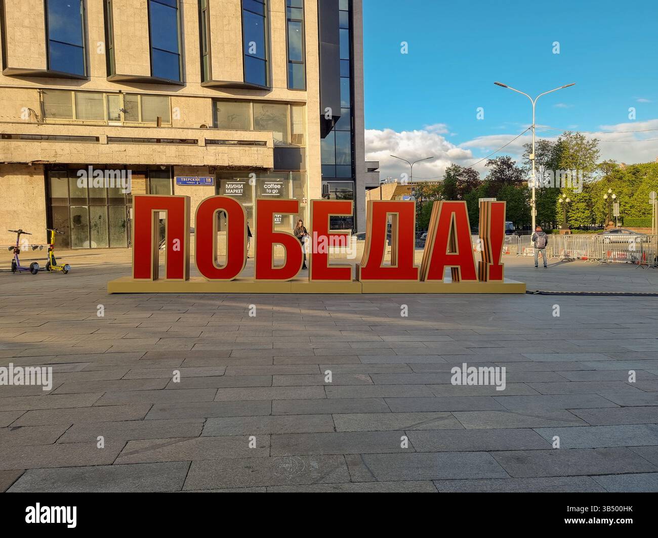 Schild für die Feier des 9. Mai 2025, 80 Jahre nach dem Sieg über die Nazis, Ende des Zweiten Weltkriegs: Rote Buchstaben des „Sieges“ auf russischem ПОБЕДА!; auf einem Platz in Moskau - Smartphone-aufgenommenes Stockfoto