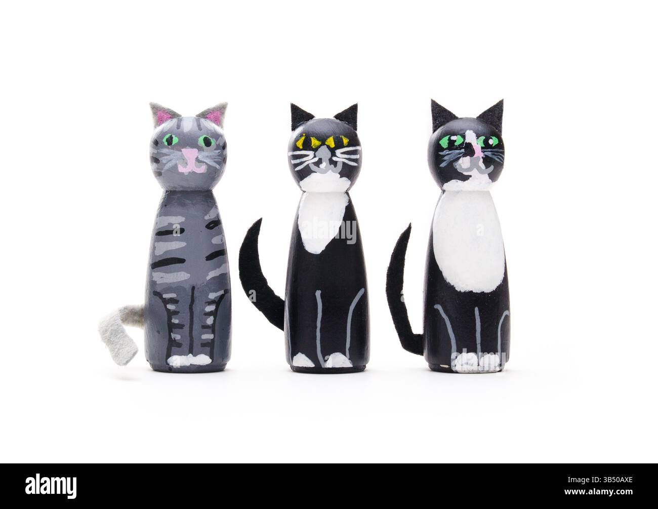 Drei Katzenfiguren auf weißem Hintergrund. Gruppe von Miniatur-Katzenstatuen, die in die Kamera schauen. Niedliche, handgemachte Katzenkatzen aus Holzstiften. Tabby und 2 Stockfoto