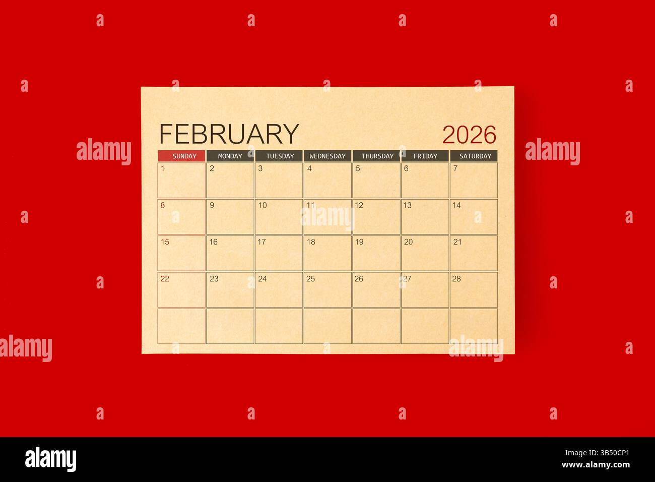 Februar 2026 Schreibtischkalender aus braunem Papier auf rotem Hintergrund. Stockfoto