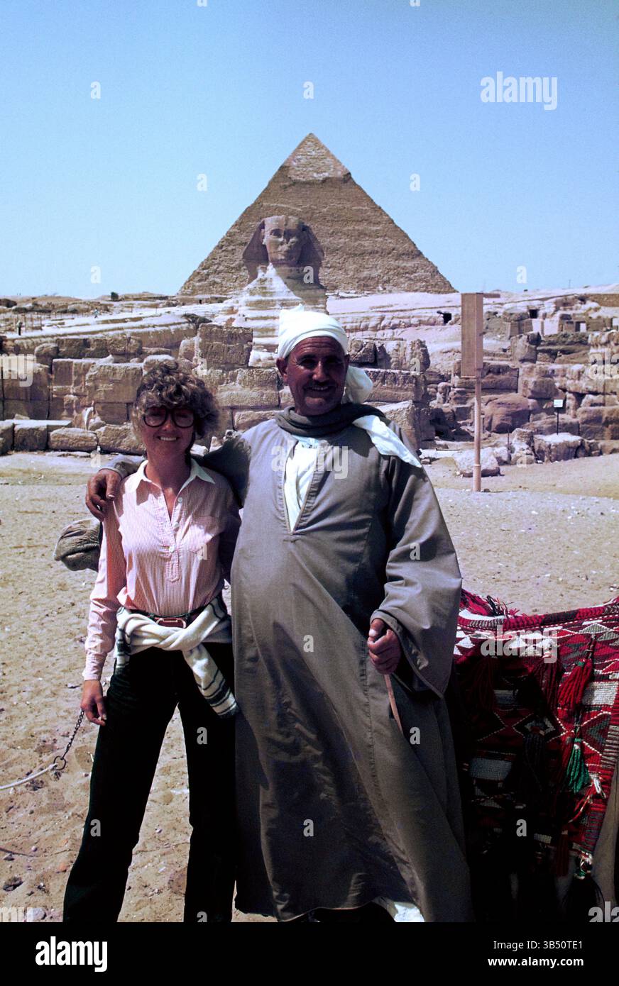 Ägypten. Gizeh. Eine Touristikerin posiert mit einem einheimischen Mann vor der Großen Sphinx. Stockfoto