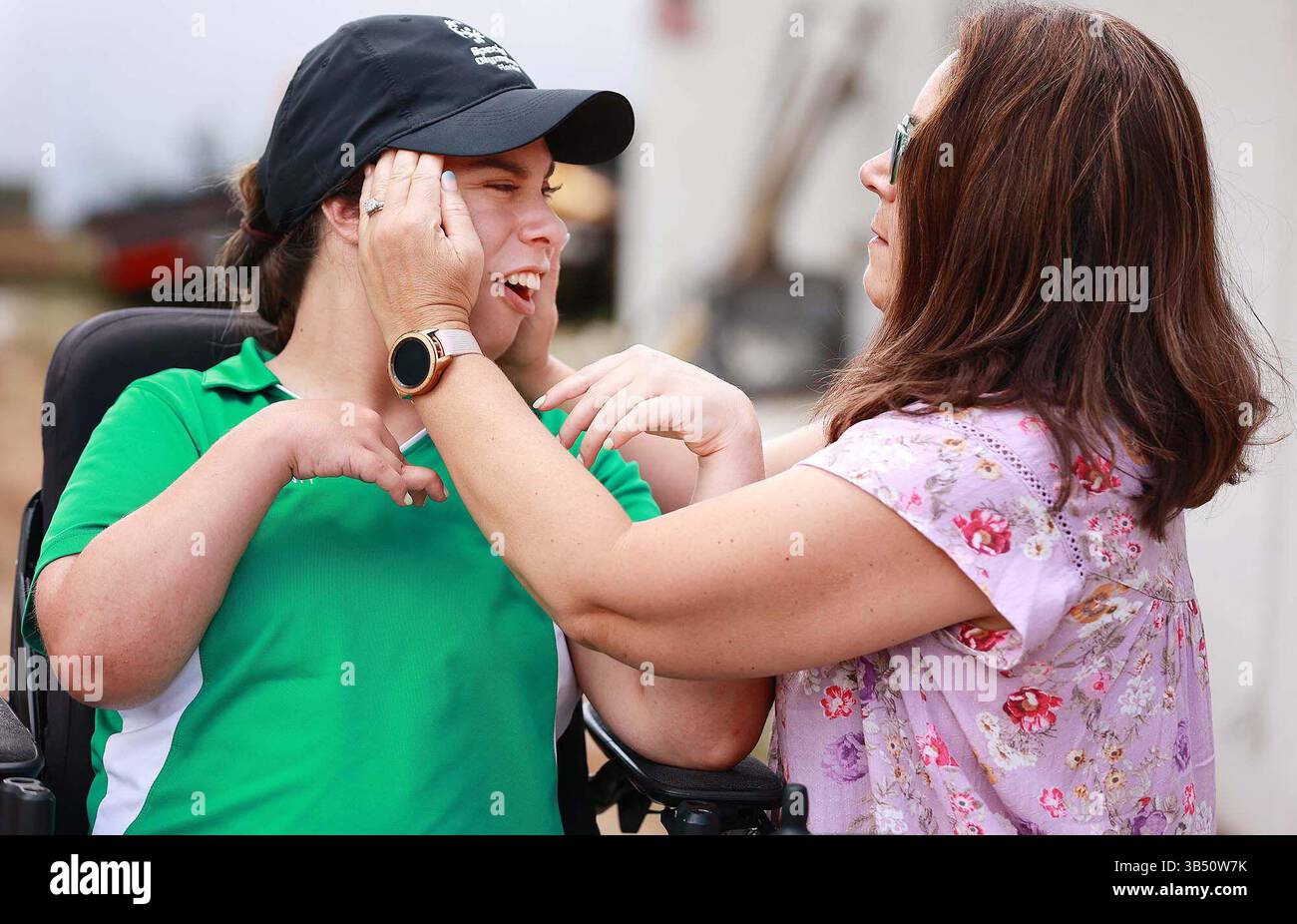 Mai 2022, Belle Isle, FL - Florida, USA: Isabelle Valle, Left, eine Special Olympics Athletin, die an Ã¢â‚¬Å”Golf SkillsÃ¢â‚¬Â-Events teilnimmt, bekommt am Freitag, den 13. Mai 2022, Hilfe beim Anziehen einer Mütze von ihrer Mutter Elaine Valle in ihrem Haus in Belle Isle. Isabelle sollte im nächsten Monat an den Special Olympics USA Games 2022 in Orlando teilnehmen, wurde aber vor kurzem gesagt, dass sie nicht zugelassen werde, weil sie nicht gegen COVID-19 geimpft sei. (Foto: © Stephen M. Dowell/Orlando Sentinel/TNS via ZUMA Press Wire) Stockfoto