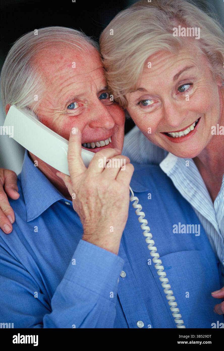 Nahaufnahme eines älteren Mannes und einer Frau drinnen, die am Telefon sprachen. Stockfoto