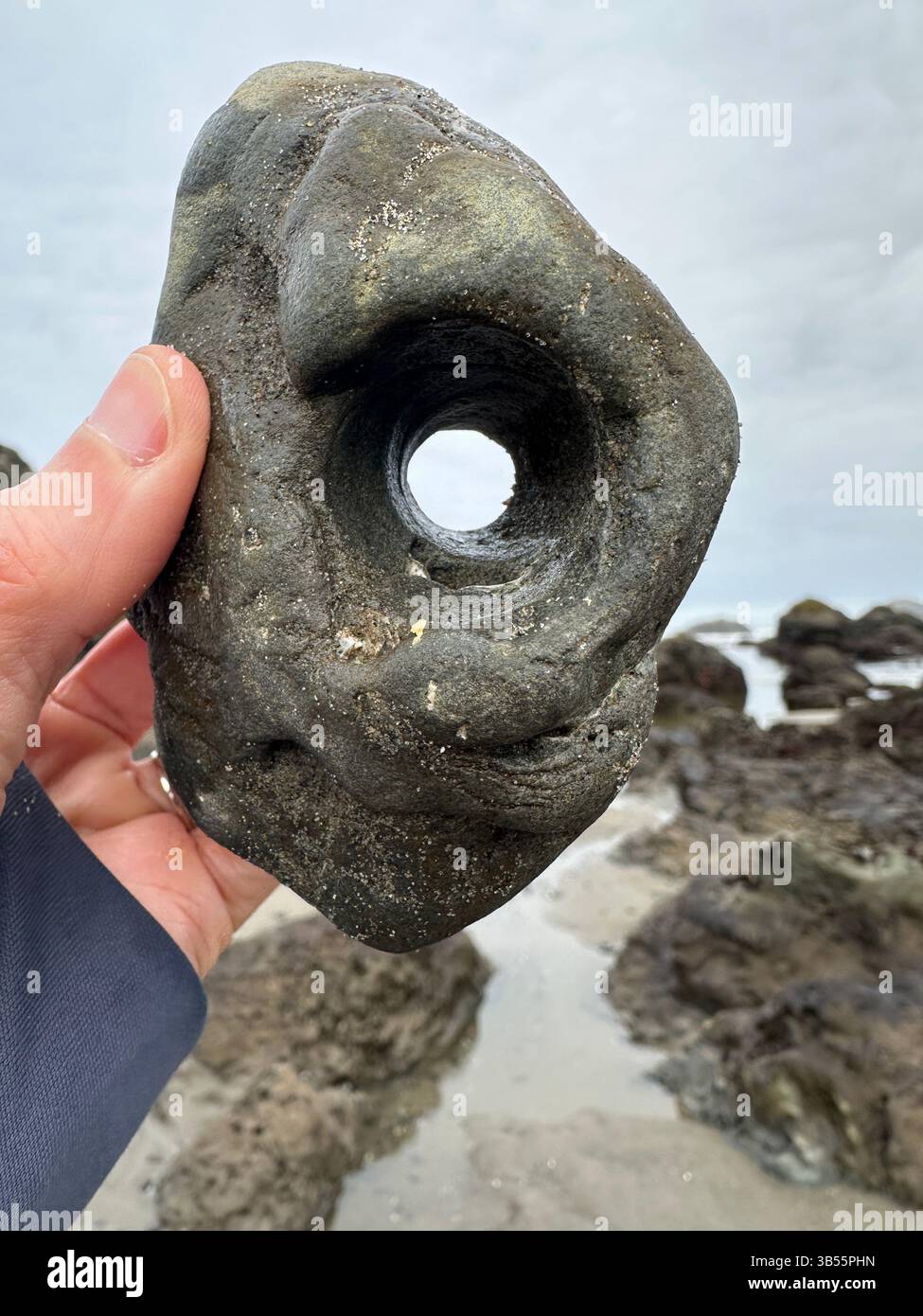 Ein Steinchen - Felsen mit einem natürlichen Loch - am Face Rock Beach in Bandon, Oregon. - Smartphone-aufgenommenes Stockfoto