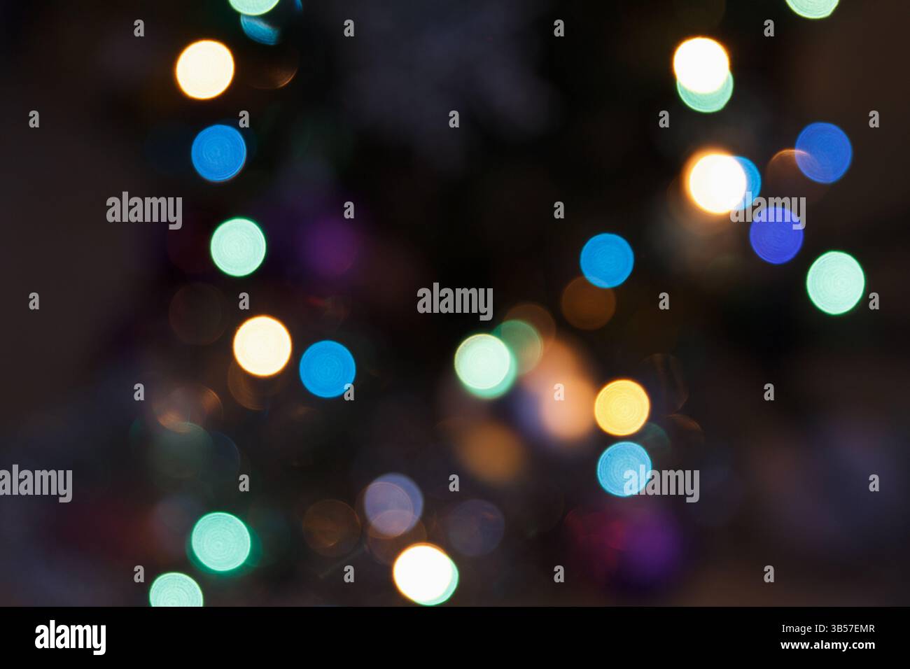 Unscharfes, mehrfarbiges Licht mit weichem Fokus auf dunklem Hintergrund. Abstrakter Bokeh-Effekt für eine wunderschöne festliche und traumhafte Atmosphäre Stockfoto
