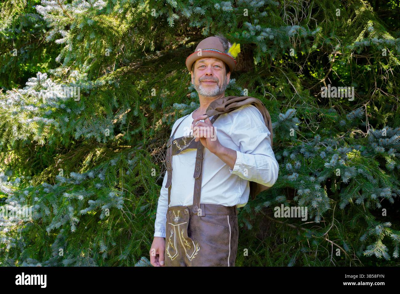 Ein Mann in Tiroler Volkstracht, der die Natur mit stolzer Haltung genießt Stockfoto
