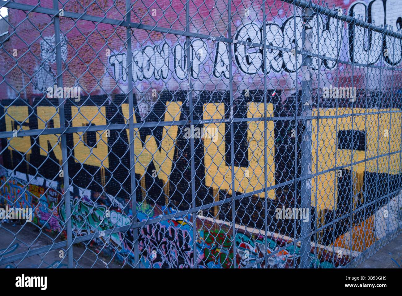 Graffiti durch einen Maschendrahtzaun entlang der West Hastings Street im Zentrum von Vancouver, BC. Stockfoto