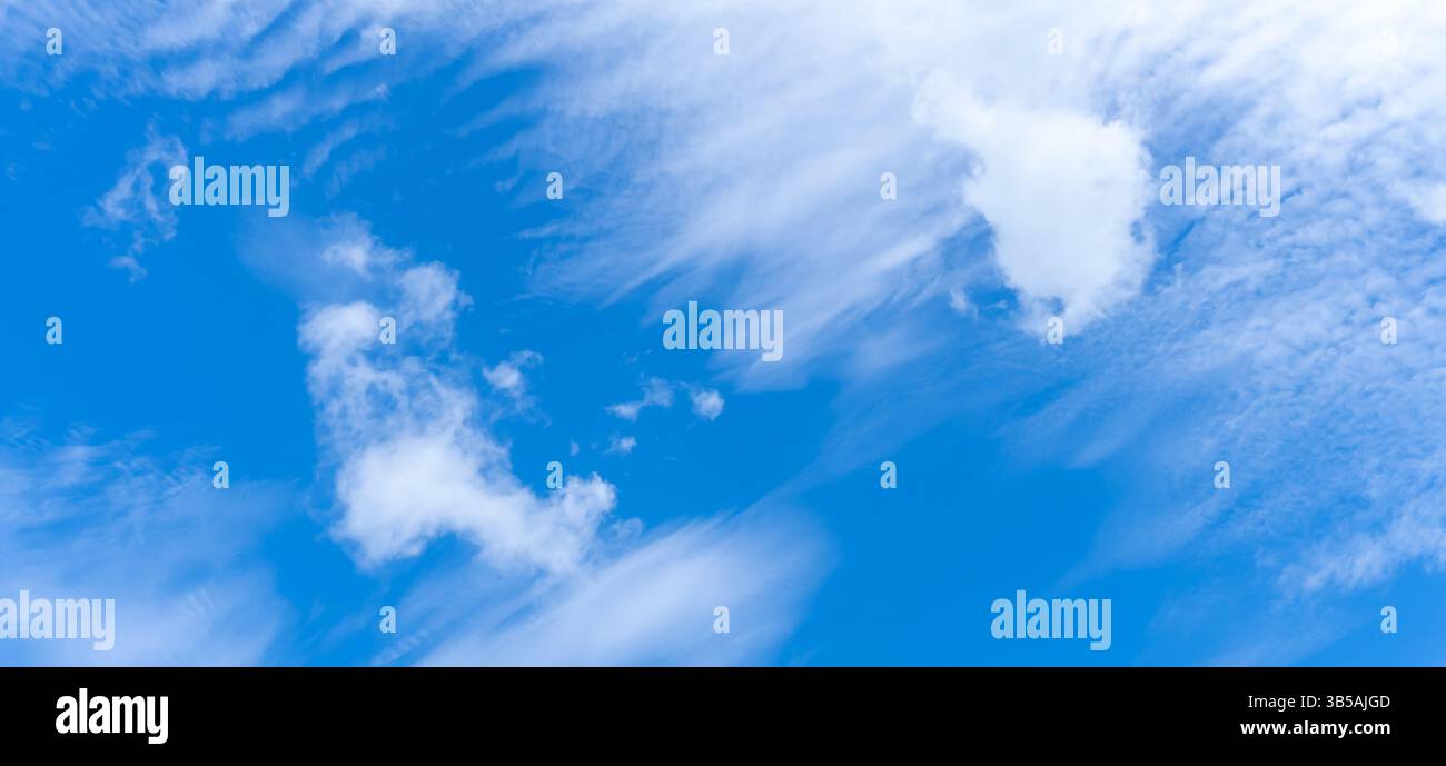 Niedriger Winkel und voller Rahmen des wunderschönen blauen Himmels mit seltsamer Form dünner weißer Wolken am Morgen oder Nachmittag an sonnigen Tagen Stockfoto