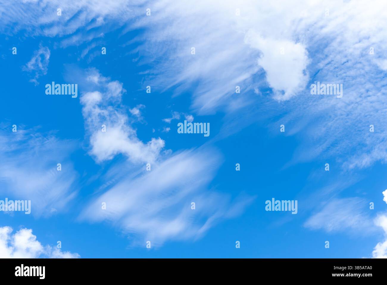 Niedriger Winkel und voller Rahmen des wunderschönen blauen Himmels mit seltsamer Form dünner weißer Wolken am Morgen oder Nachmittag an sonnigen Tagen Stockfoto