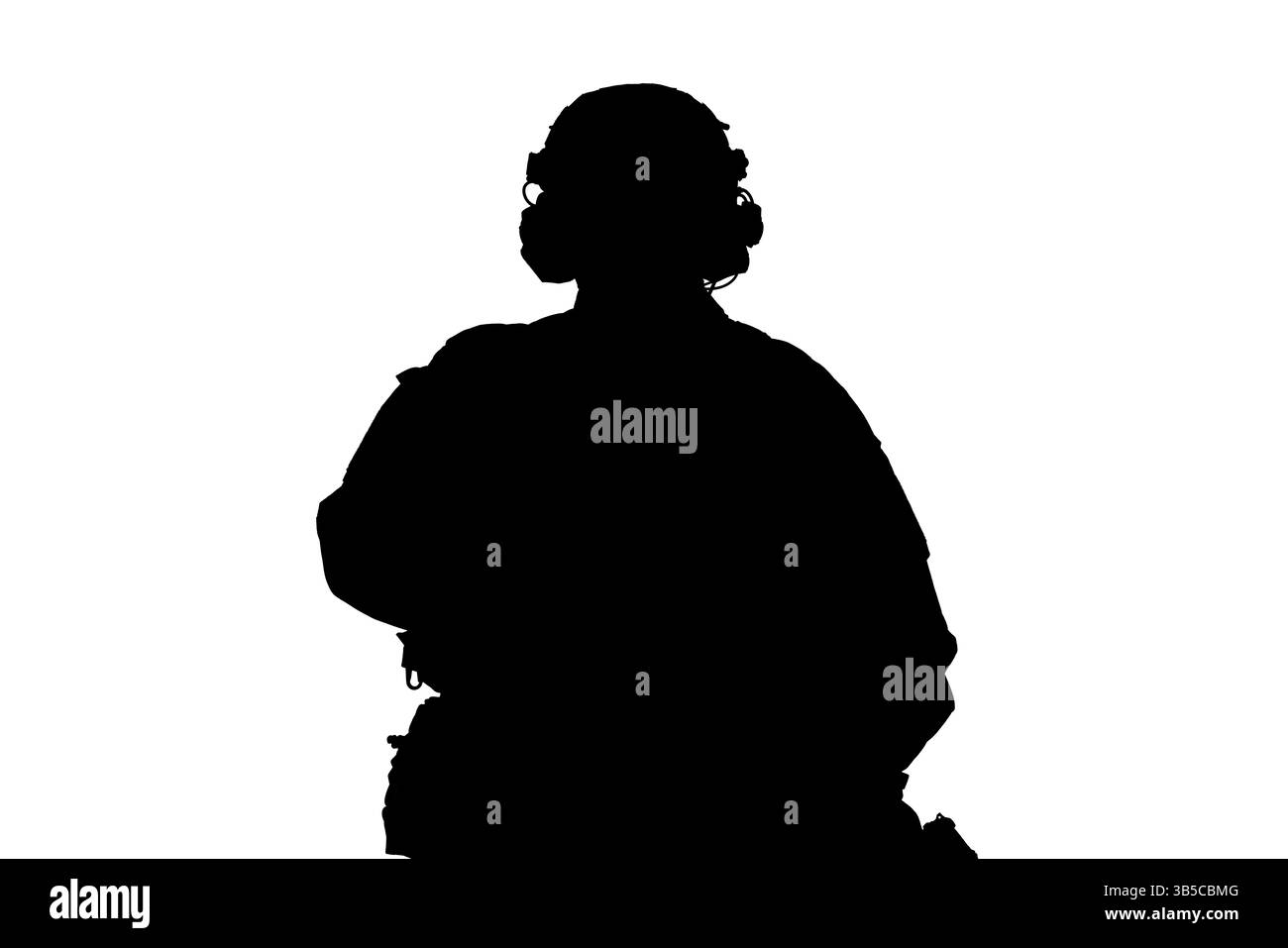 Eine auffällige Silhouette, die eine Person in taktischer Ausrüstung, einschließlich Headset und robustem Outfit, zeigt, was eine dramatische und professionelle Atmosphäre schafft Stockfoto