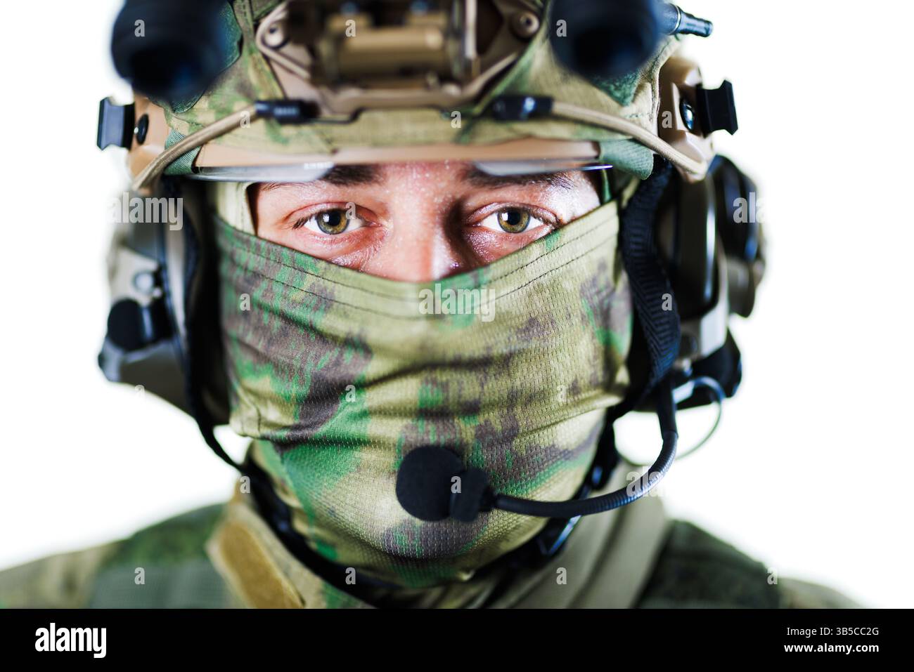 Eine detaillierte Nahaufnahme eines Soldaten mit Tarnschutz, taktischem Helm und Kommunikationsausrüstung. Das Bild vermittelt Themen wie Sicherheit, Professionalität Stockfoto