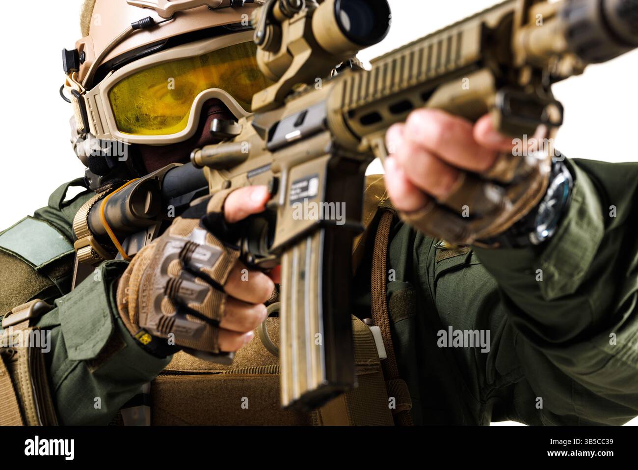 Ein gut ausgebildeter Soldat, der taktische Ausrüstung trägt und mit einem Kampfgewehr zielt, der Präzision, Wachsamkeit und Bereitschaft in einer kontrollierten Mühle zum Ausdruck bringt Stockfoto