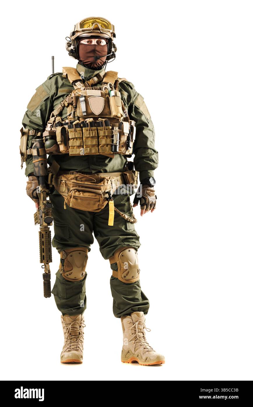 Militärpersonal, das mit fortschrittlicher taktischer Ausrüstung, einschließlich Körperpanzerung und Helm, ausgestattet ist und ein Gewehr in einem einsatzbereiten Stand hält. Professionell trai Stockfoto