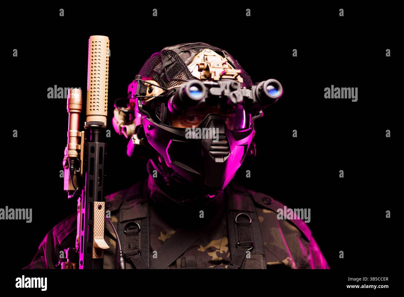 Ein kampfbereiter Soldat mit modernster taktischer Ausrüstung, einschließlich Helm, Nachtsichtbrille und Waffe, beleuchtet unter dramatischer Beleuchtung Stockfoto
