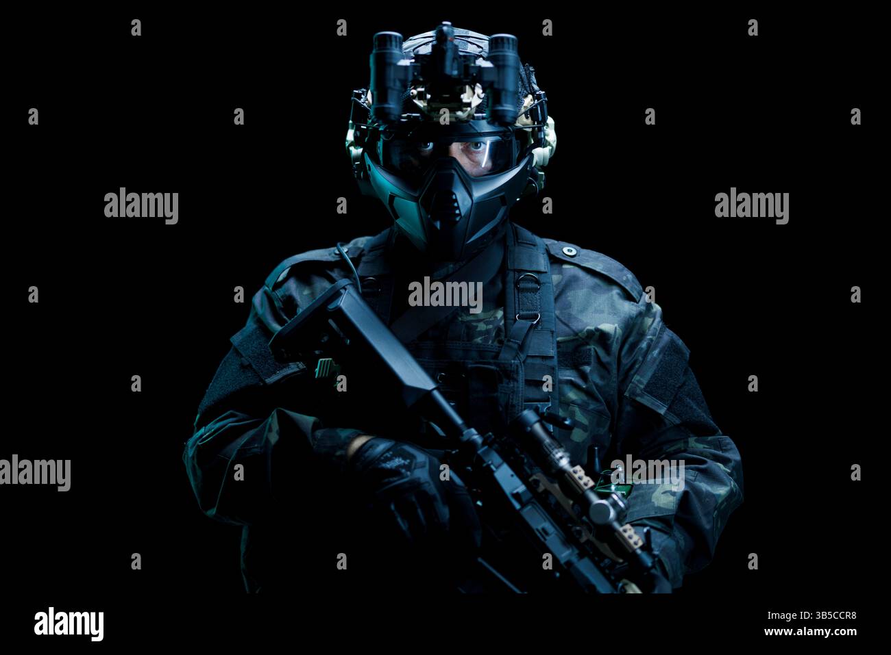 Gepanzerter Soldat mit fortschrittlicher Kampfausrüstung, einschließlich Nachtsichtbrille, in einer dramatischen Umgebung. Zeigt Themen wie Präzision und Professionalität Stockfoto