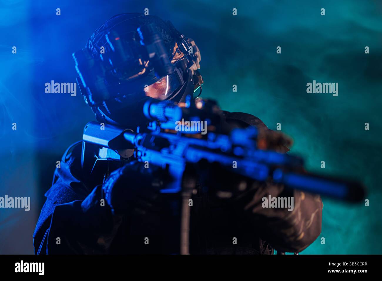 Ein Soldat mit taktischer Ausrüstung, einschließlich Gewehr und Helm mit Nachtsicht, bereitet sich in einer rauchigen Umgebung auf Operationen vor. Die Stockfoto