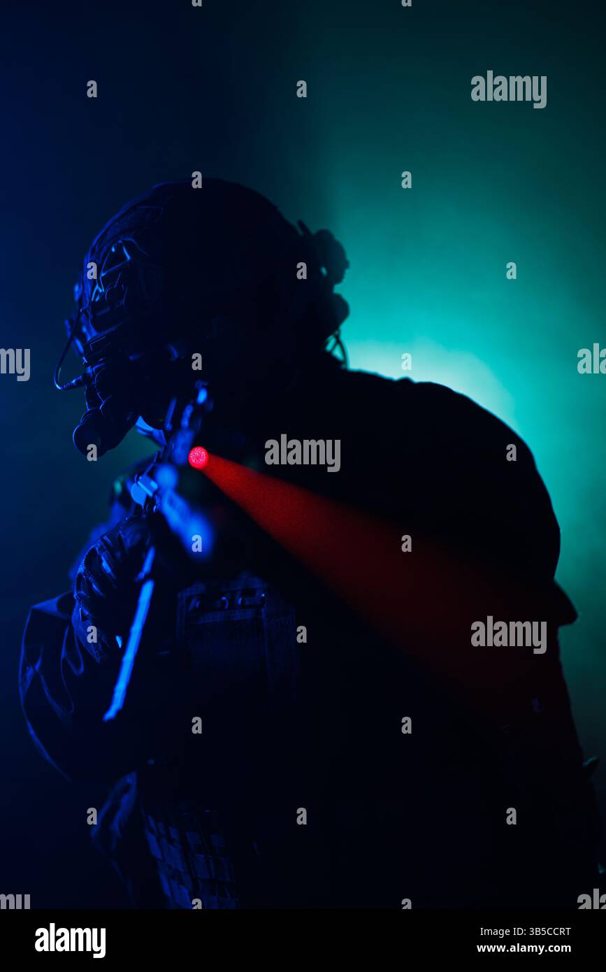 Ein Soldat in taktischer Ausrüstung zielt auf eine Waffe mit rotem Laservisier, umgeben von dynamischer blauer Beleuchtung und Nebel. Die Szene ist intensiv und erzeugt einen Sinn Stockfoto