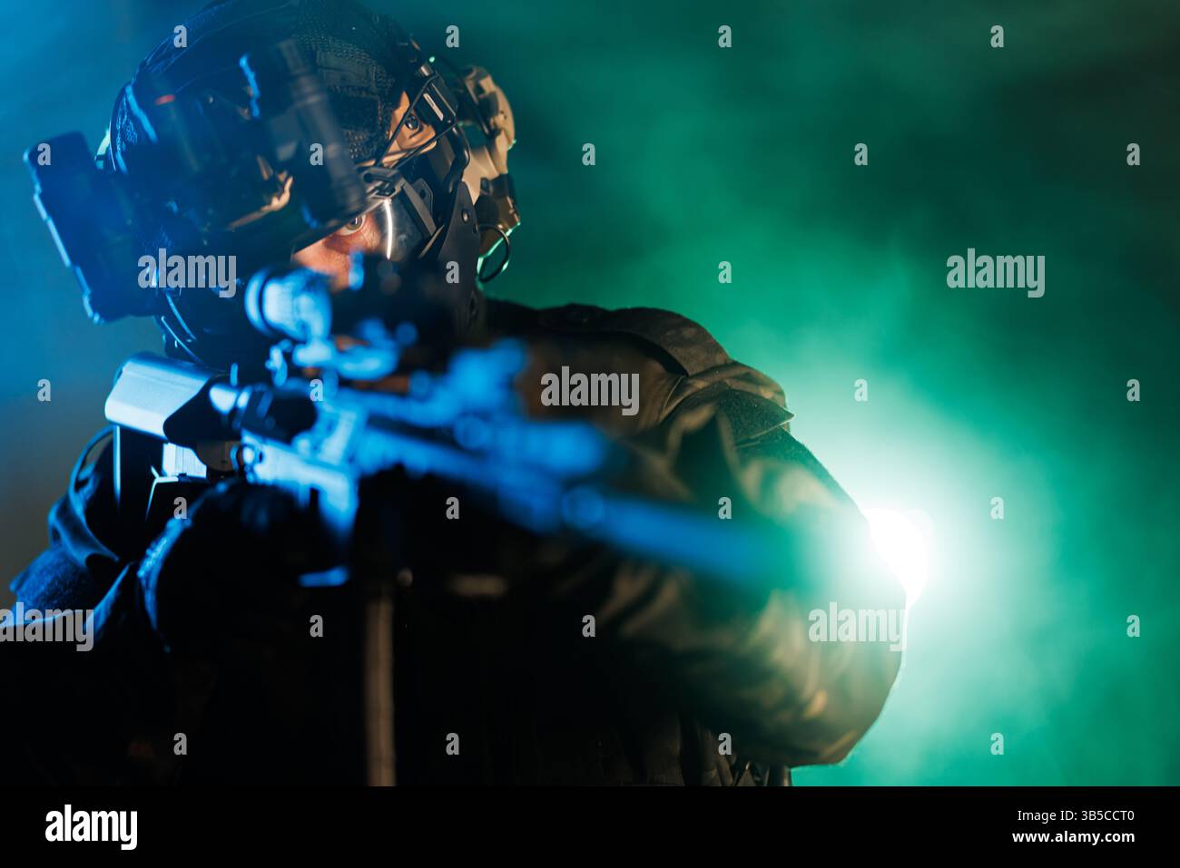 Bediener in taktischer Ausrüstung, der eine Waffe unter gedämpfter Beleuchtung anvisiert, bereit für die Aktion. Stockfoto