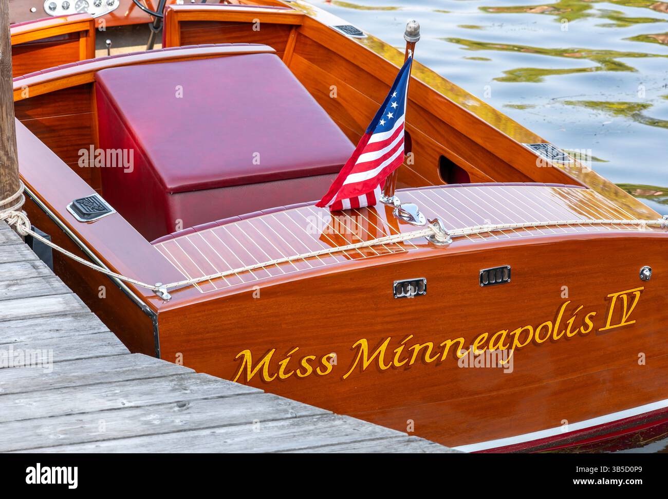 NISSWA, MN - 12. SEP 2024: Stern eines klassischen Vintage-Holzbootes, mit einem Seil an einem Dock gebunden, auf einem Minnesota-See. Stockfoto