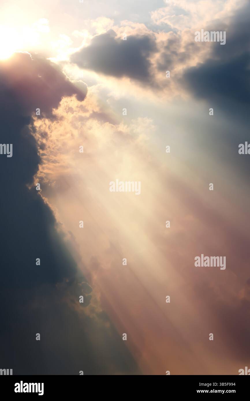 Geheimnisvolles und fantastisches Sonnenlicht, das durch die Wolken scheint, helle und intensive Lichtstrahlen, schöner Himmelhintergrund Stockfoto
