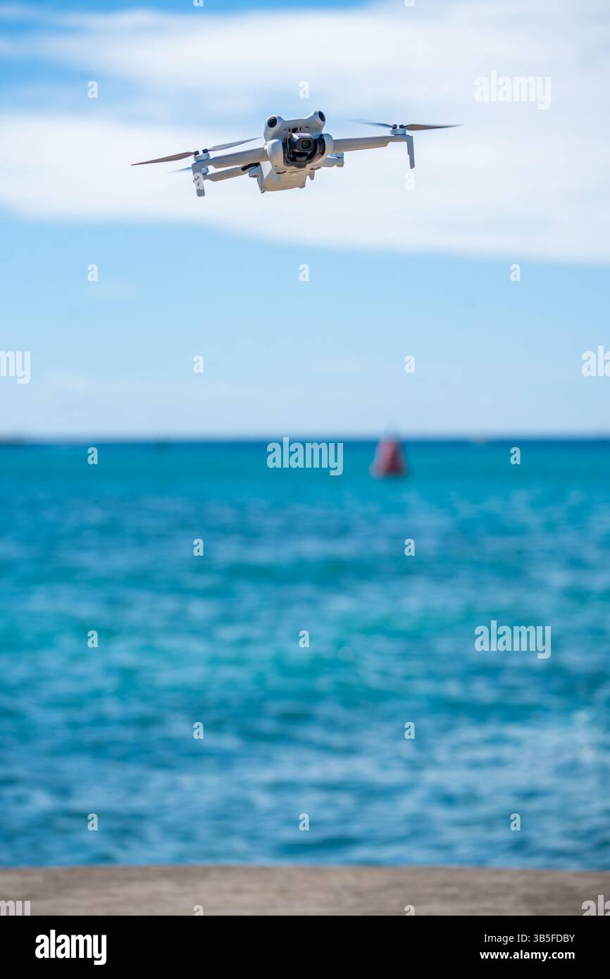 Moderne Drohne fliegt mitten in der Luft mit blauem Himmel, die fortschrittliche Lufttechnologie und Innovation in Fotografie, Überwachung und Freizeit zeigt Stockfoto