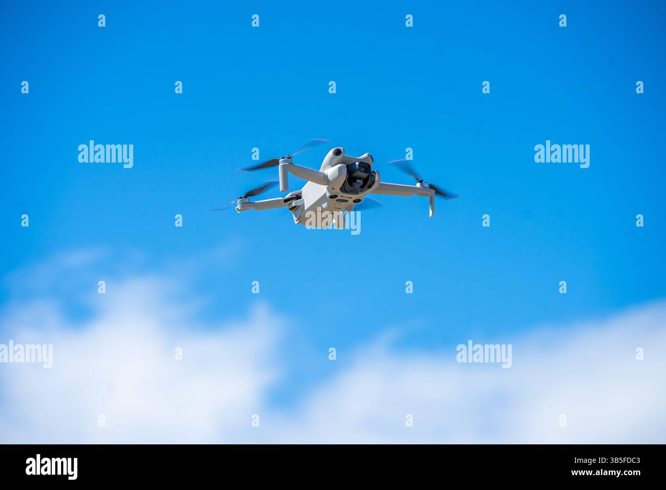 Moderne Drohne fliegt mitten in der Luft mit blauem Himmel, die fortschrittliche Lufttechnologie und Innovation in Fotografie, Überwachung und Freizeit zeigt Stockfoto