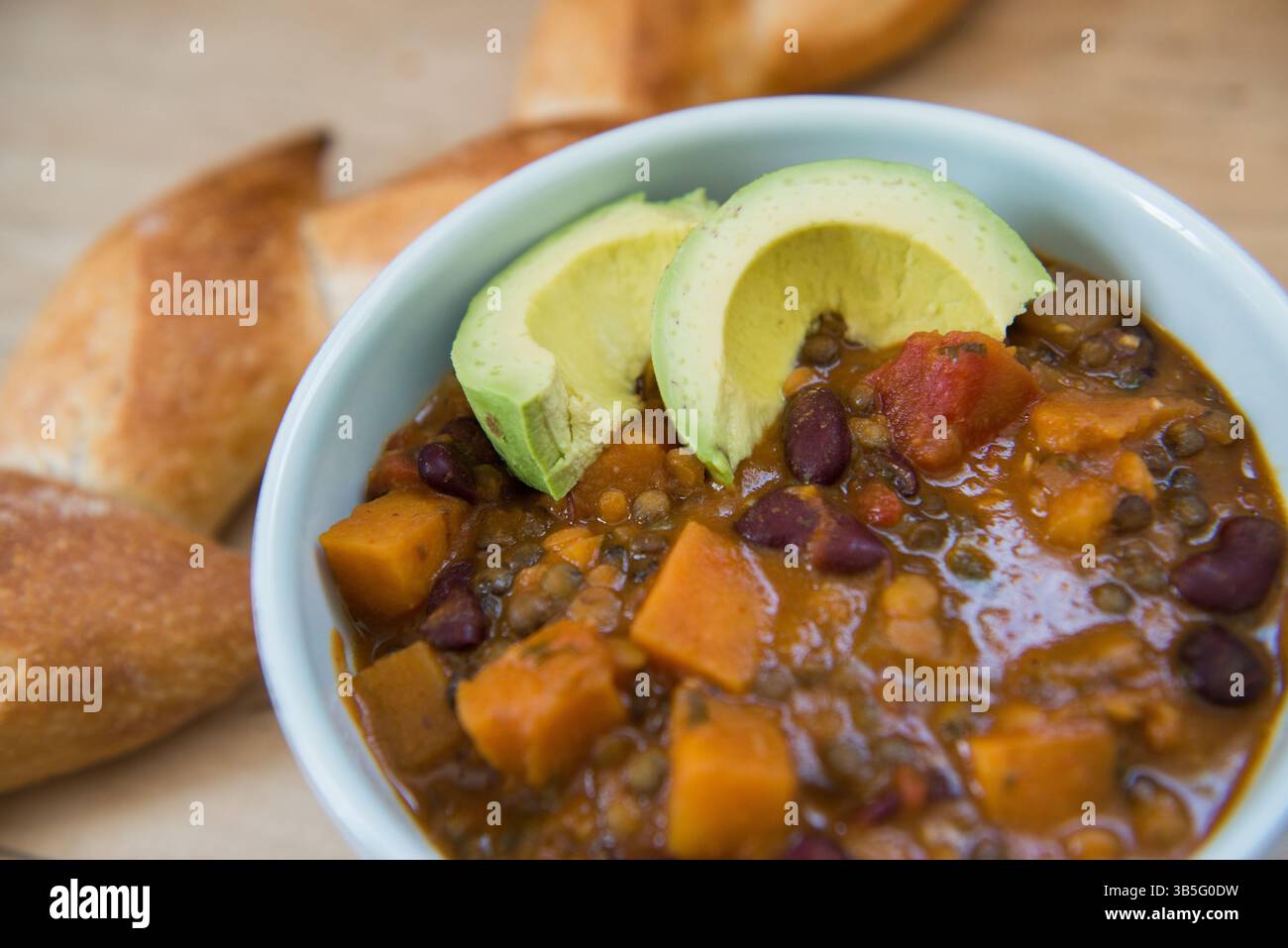 Vegane Chili mit Avocado und Brot – Eine herzhafte Mahlzeit auf Pflanzenbasis Stockfoto