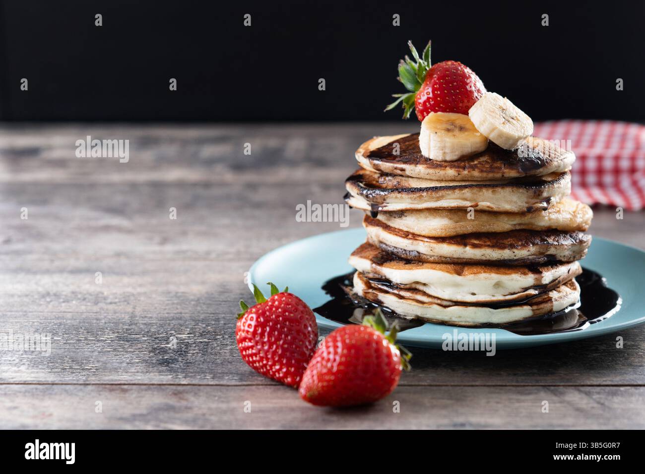 Pfannkuchen mit Schokolade und Obst auf Holztisch Stockfoto