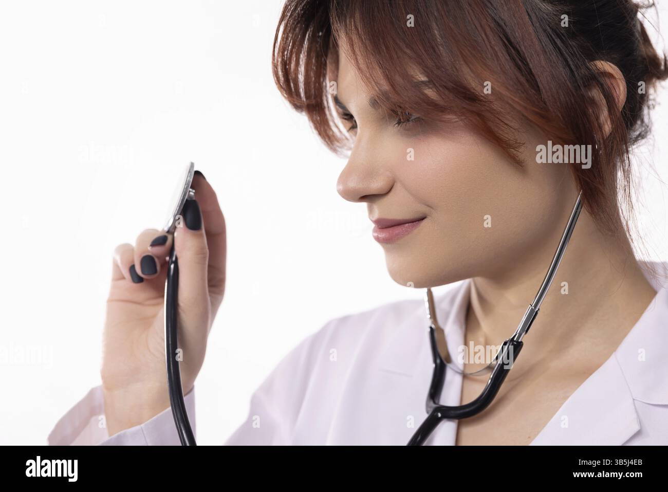 Ein engagierter Gesundheitsdienstleister setzt aufmerksam ein Stethoskop ein, das Mitgefühl, Pflege und Professionalität repräsentiert Stockfoto