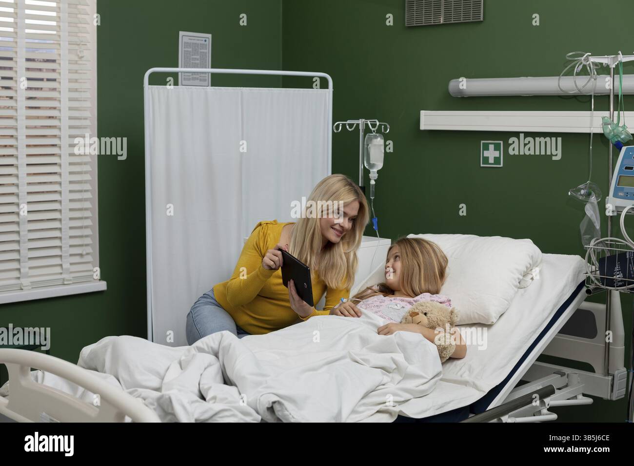 Ein berührender und fürsorglicher Moment, der zwischen einer hingebungsvollen Mutter und ihrem geliebten Kind in einem Krankenhaus geteilt wird Stockfoto