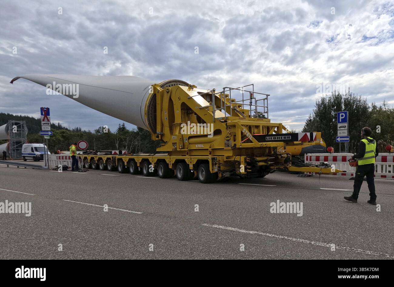 Die Windbedingungen sind gut, der Läufer ist bereit und der selbstfahrende Transporter kann mit dem Transport des 68 Meter langen Rotorblatts vom Fel beginnen Stockfoto