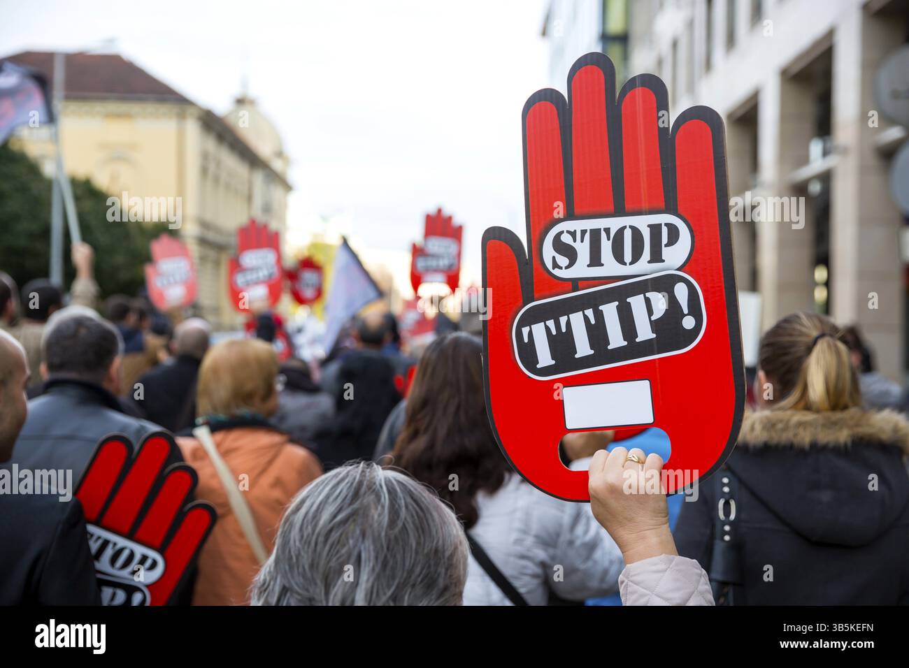 Aktivisten halten während einer Demonstration gegen die Freihandelsabkommen TTIP, CETA und TISA zwischen der EU und den USA in Sofia rote Handzeichen. Stockfoto
