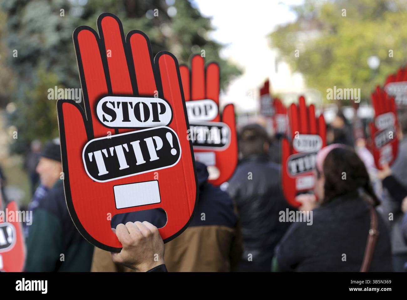 Aktivisten halten während einer Demonstration gegen die Freihandelsabkommen TTIP, CETA und TISA zwischen der EU und den USA in Sofia rote Handzeichen. Stockfoto