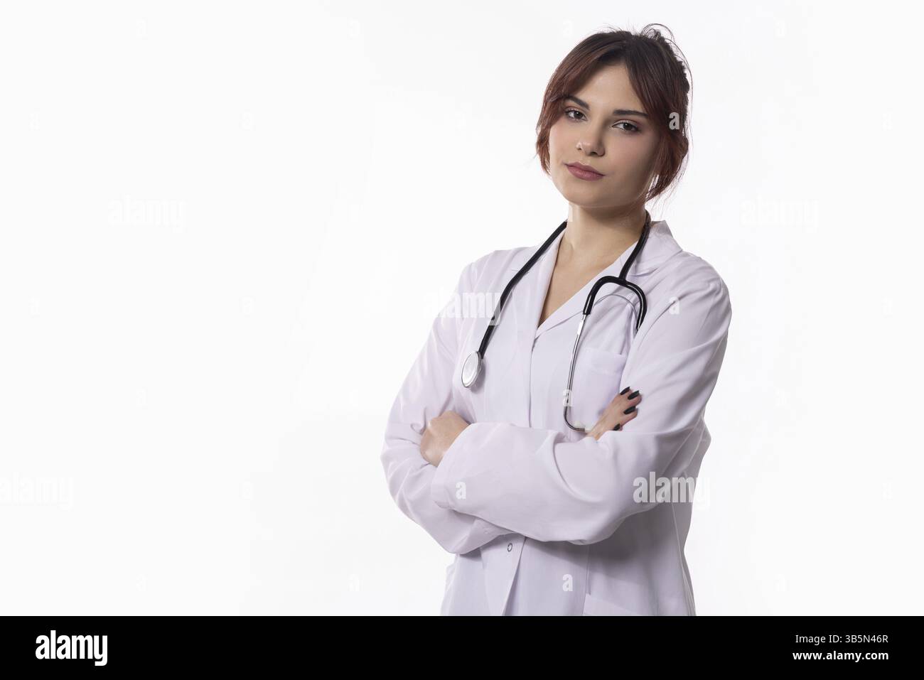 Eine hochqualifizierte und professionelle Ärztin steht mit gekreuzten Armen zuversichtlich und steht allen Patienten zur Seite Stockfoto