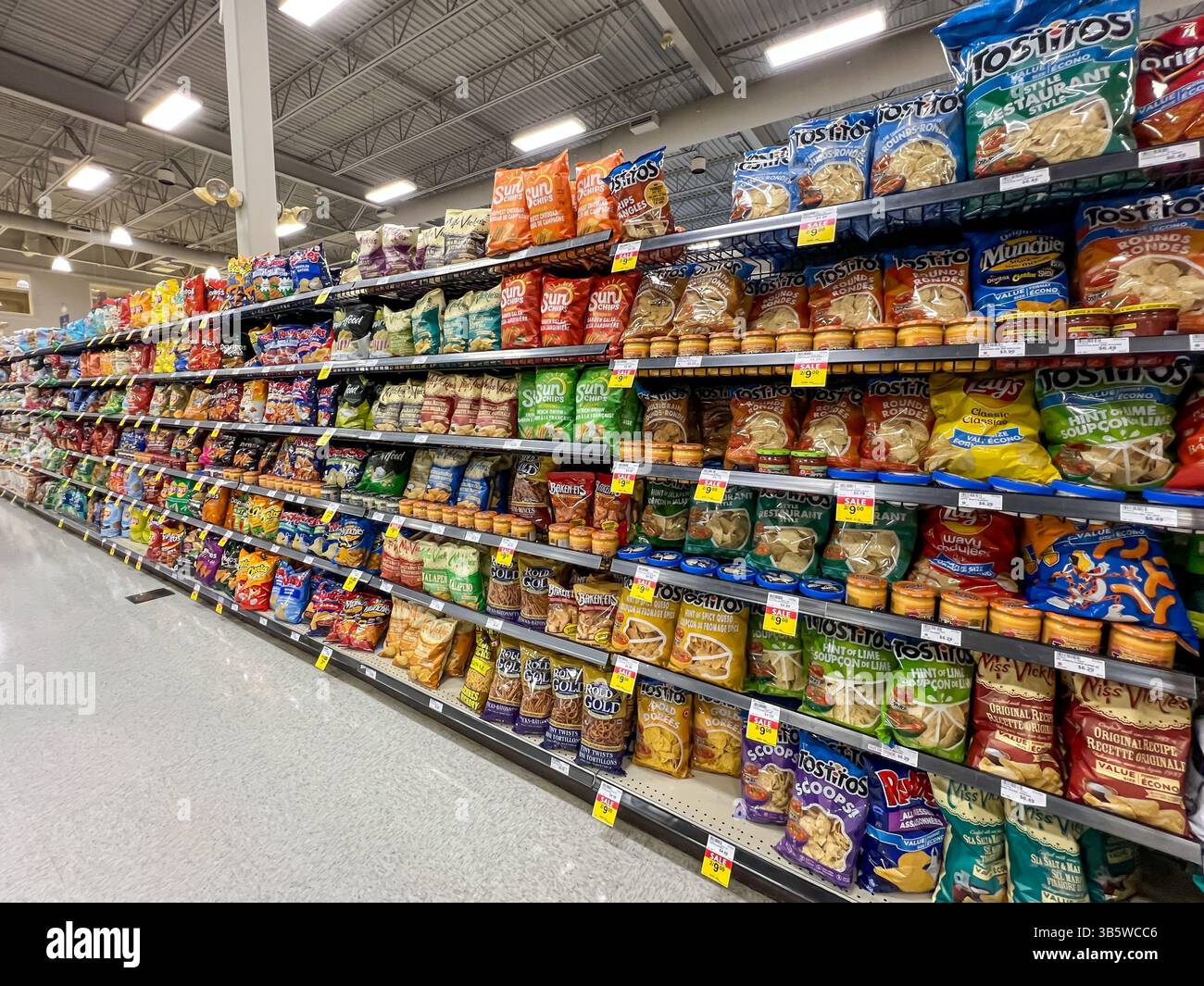Verschiedene Chips und Snacks zum Verkauf in den Regalen in einem Supermarkt. Alberta, Kanada. Stockfoto