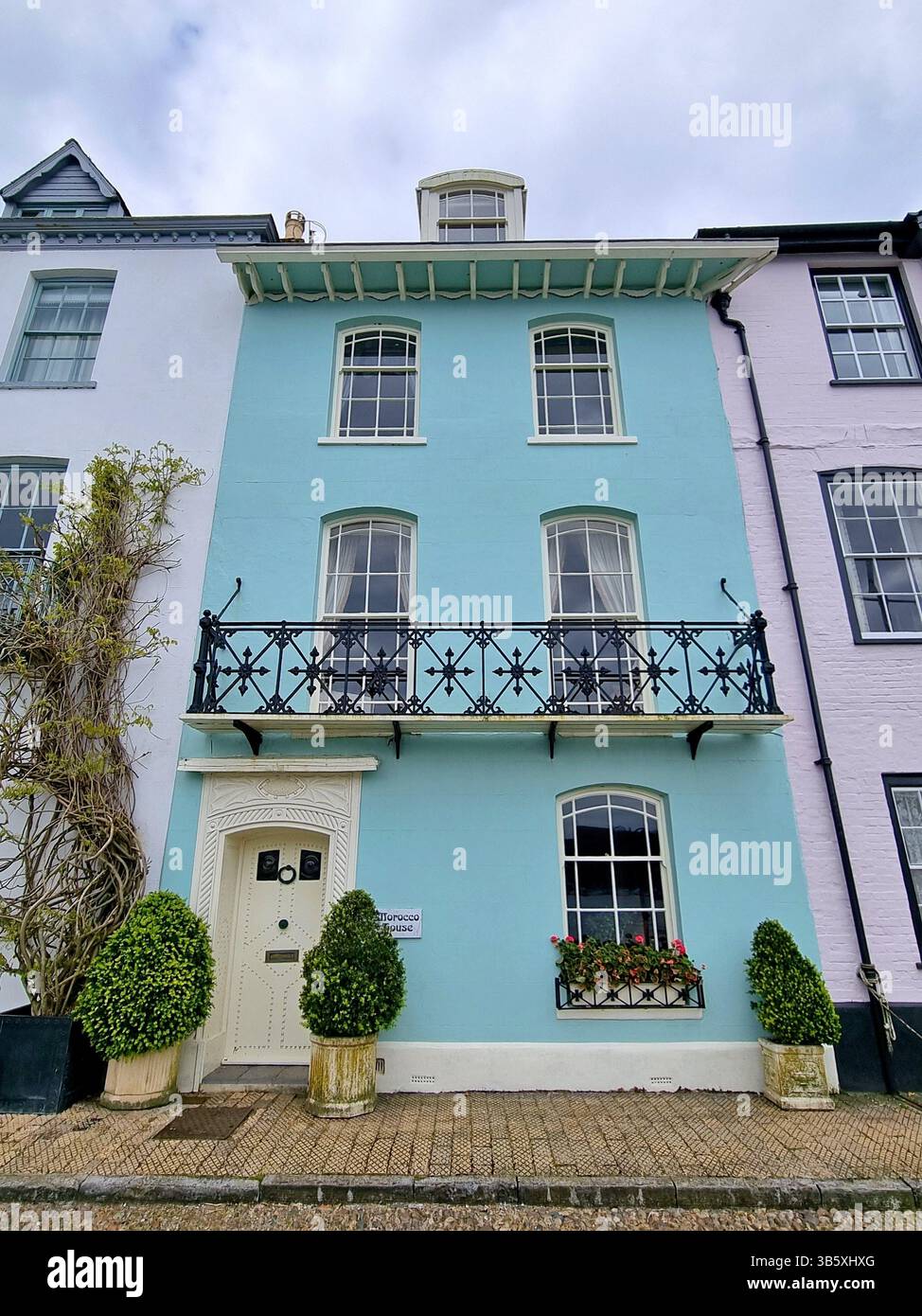 Blick auf die pastellfarbene Fassade des georgianischen Gebäudes des ehemaligen Kaufmanns Marokko House am Kai in der historischen Bayards Cove, Dartmouth, Devon, Großbritannien Stockfoto