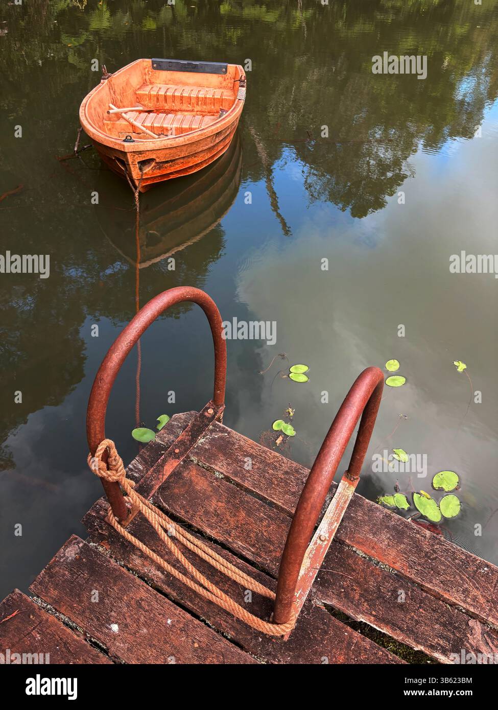 Ein kleines Ruderboot, das an einen Ricketty-Steg gebunden ist - Smartphone-aufgenommenes Stockfoto
