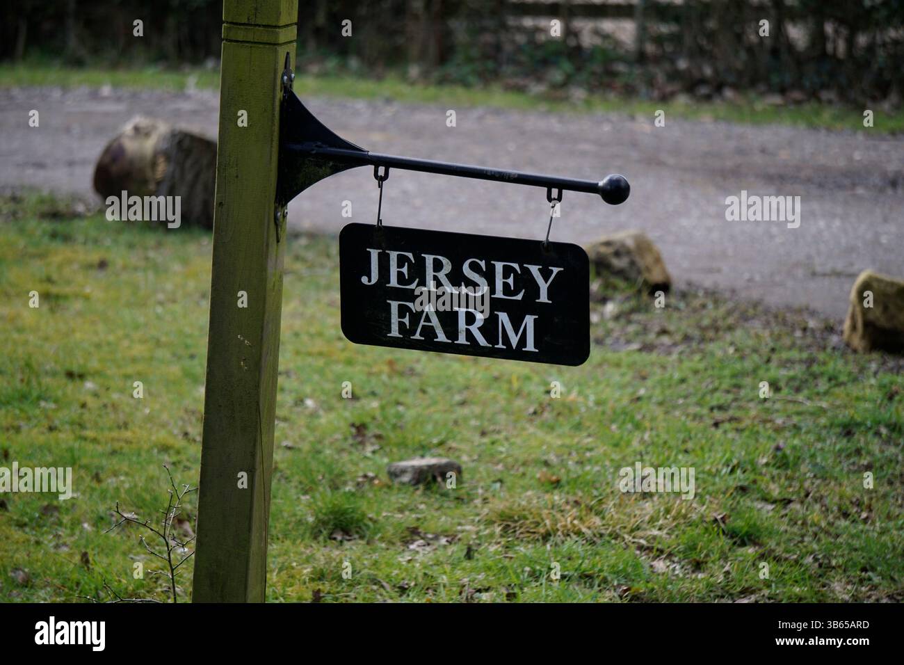 Traditionelles Einfahrtsschild auf der Jersey Farm an einem Holzpfosten in der englischen Landschaft. Leith Hill, England Stockfoto