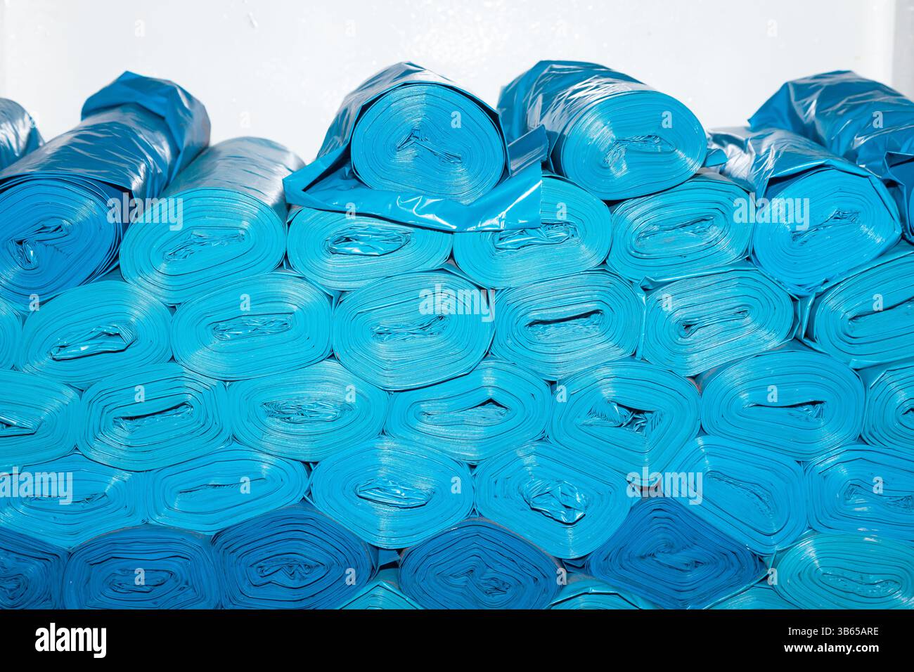 Neue blaue Kunststoffbeutel werden gerollt und übereinander gestapelt. Stockfoto