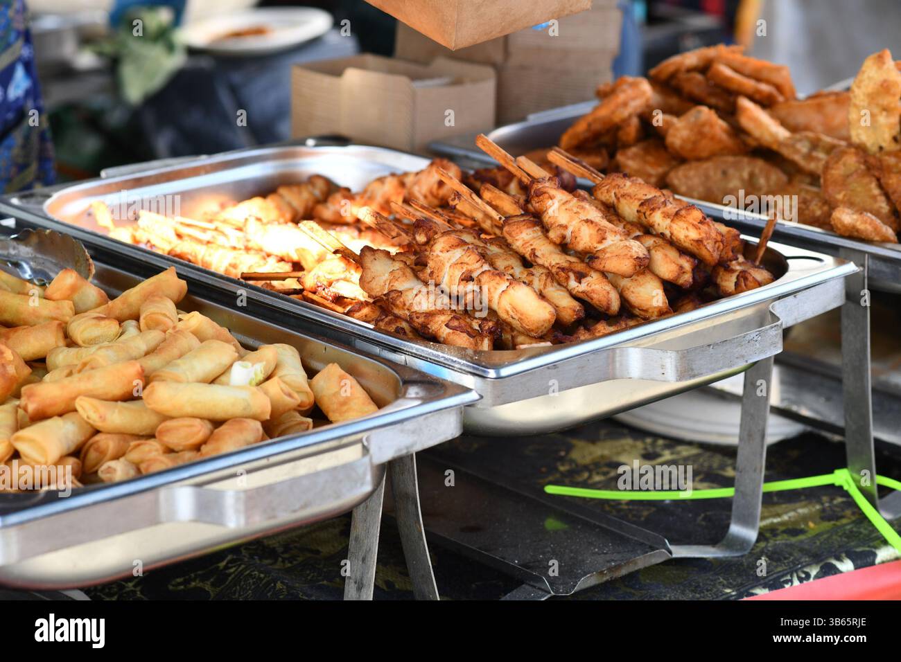 Frittiertes thailändisches Streetfood wie Frühlingsbrötchen und Hähnchenspieße Stockfoto