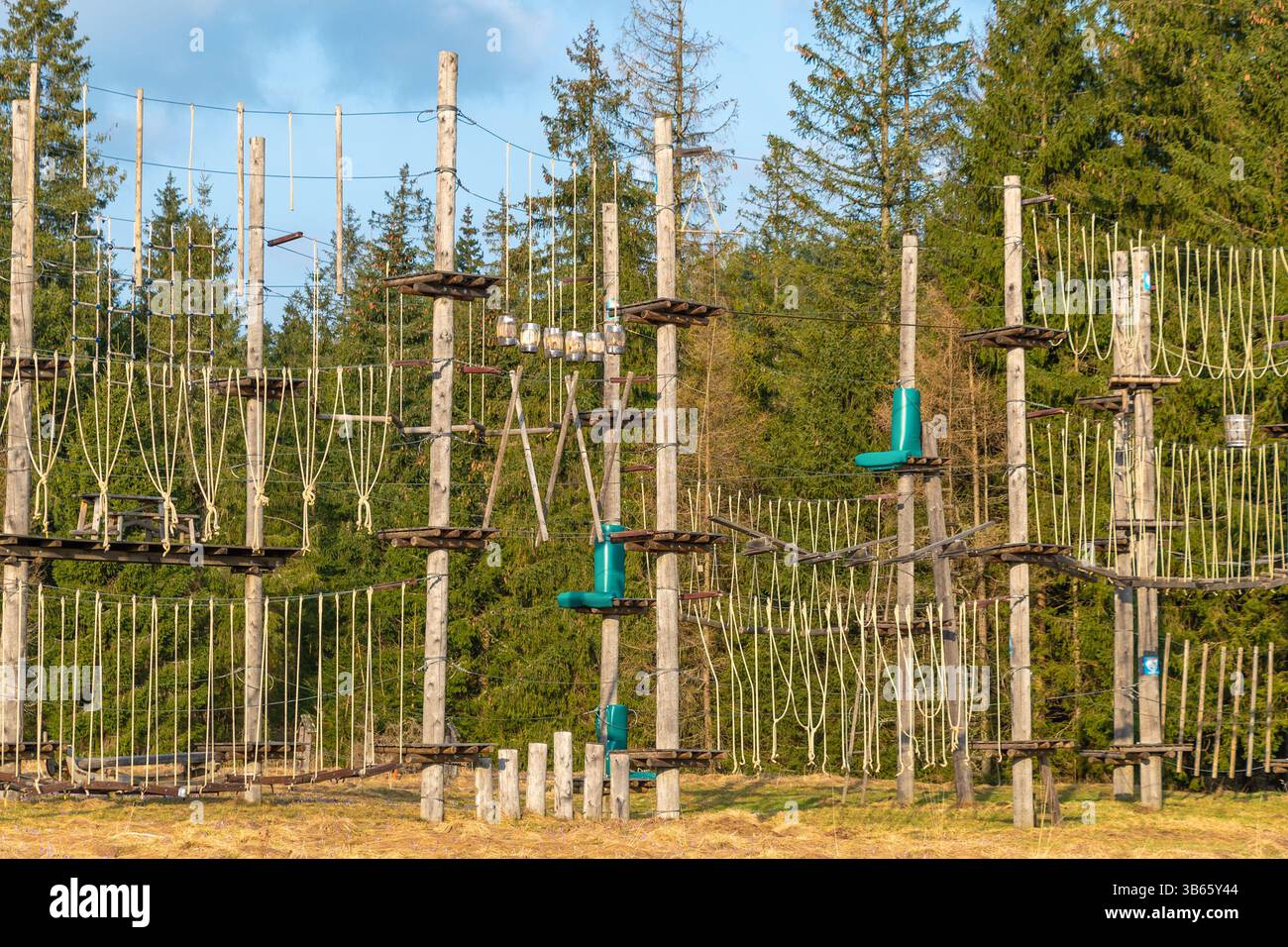 Ein Seilgarten steht auf einer Lichtung, umgeben von Wald. Outdoor-Abenteuer-Herausforderungen für Klettern und Balance. Aktive Freizeit Stockfoto