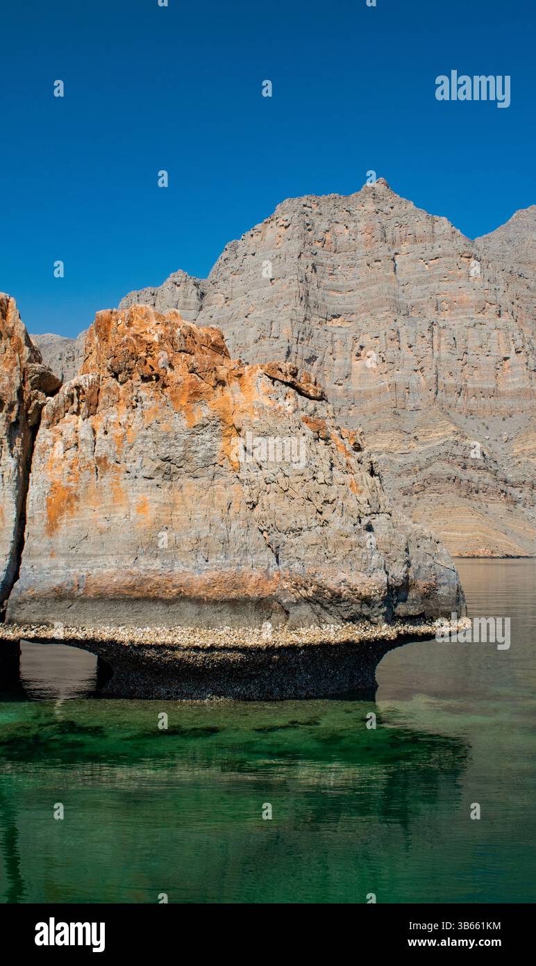 Oman: Berge, Felsformationen und kleine Inseln in den ruhigen Gewässern der Straße von Hormuz, die in den Wüstenfjorden der Halbinsel Musandam fahren Stockfoto