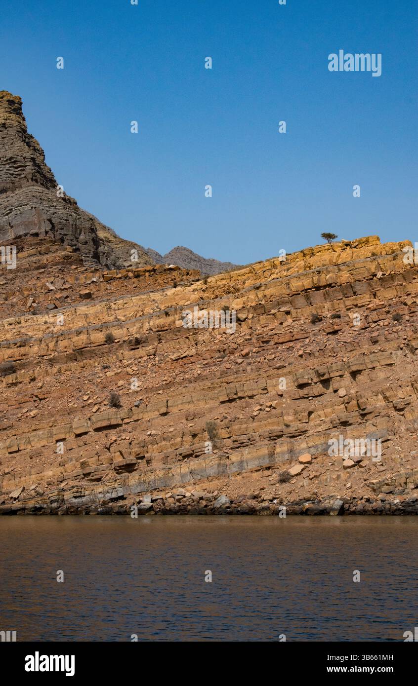 Oman: Berge, Felsformationen und kleine Inseln in den ruhigen Gewässern der Straße von Hormuz, die in den Wüstenfjorden der Halbinsel Musandam fahren Stockfoto