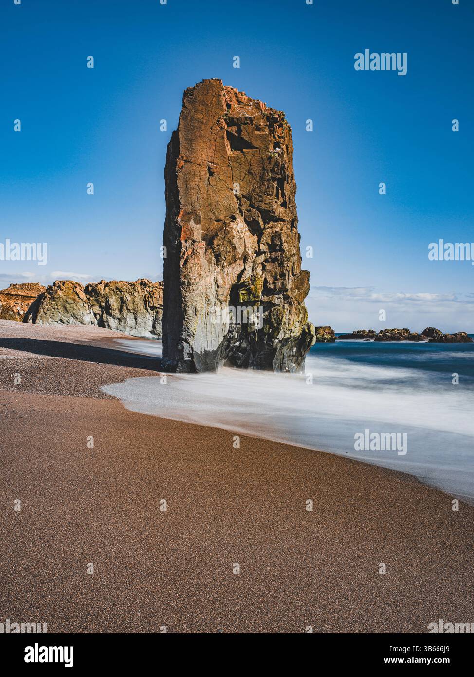 Meeresstapel an einem schwarzen Sandstrand in der Nähe von Stapavík, Ost-Island, mit weichem, langanhaltendem Wasser Stockfoto